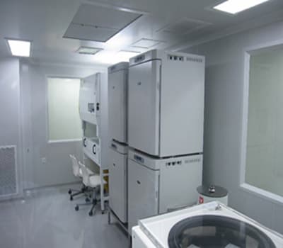The interior of a cleanroom suite showing freezers, an incubator and a biosafety cabinet along the wall.